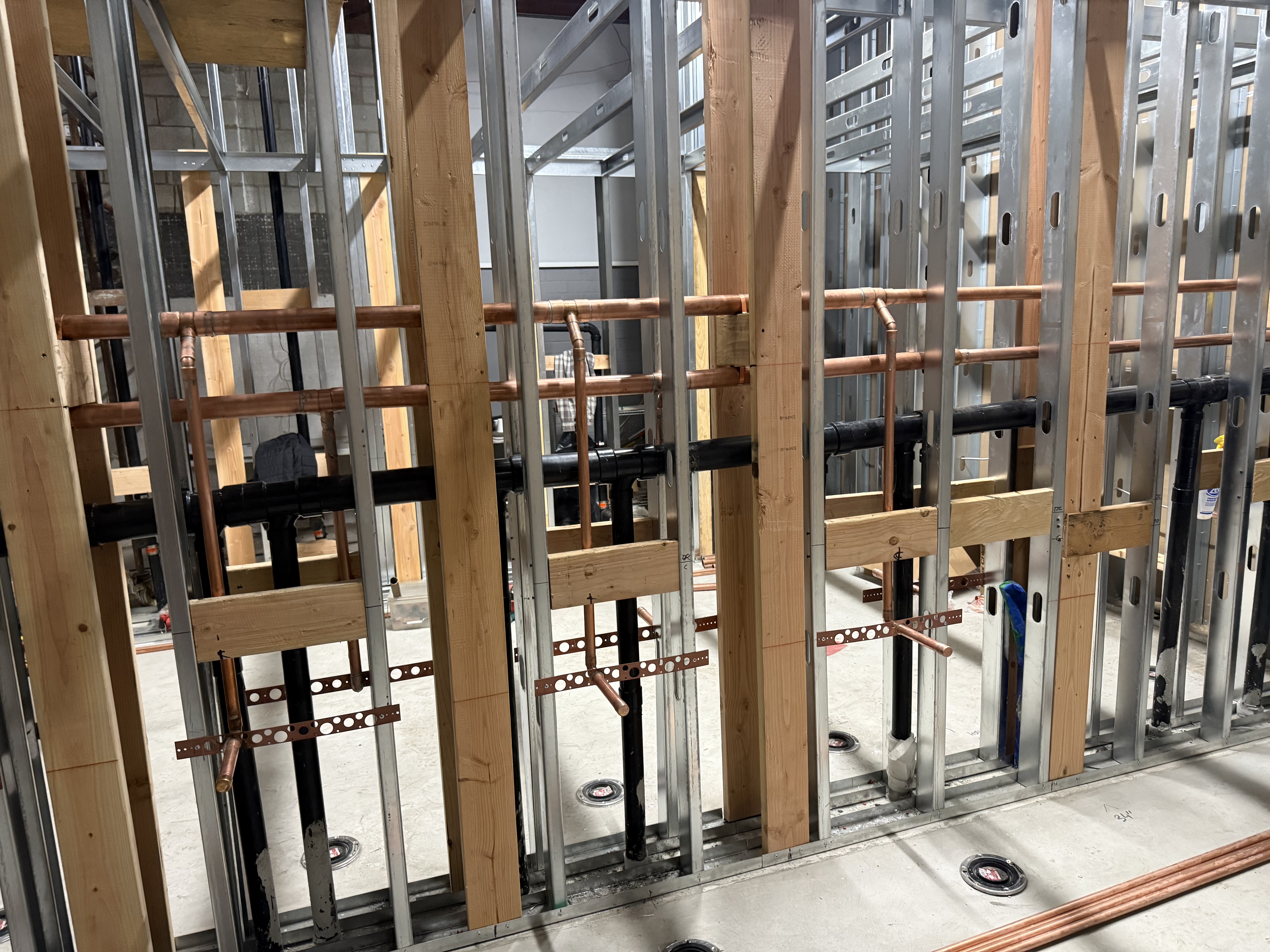Commercial bathroom rough-in plumbing — stub-outs and vent lines
