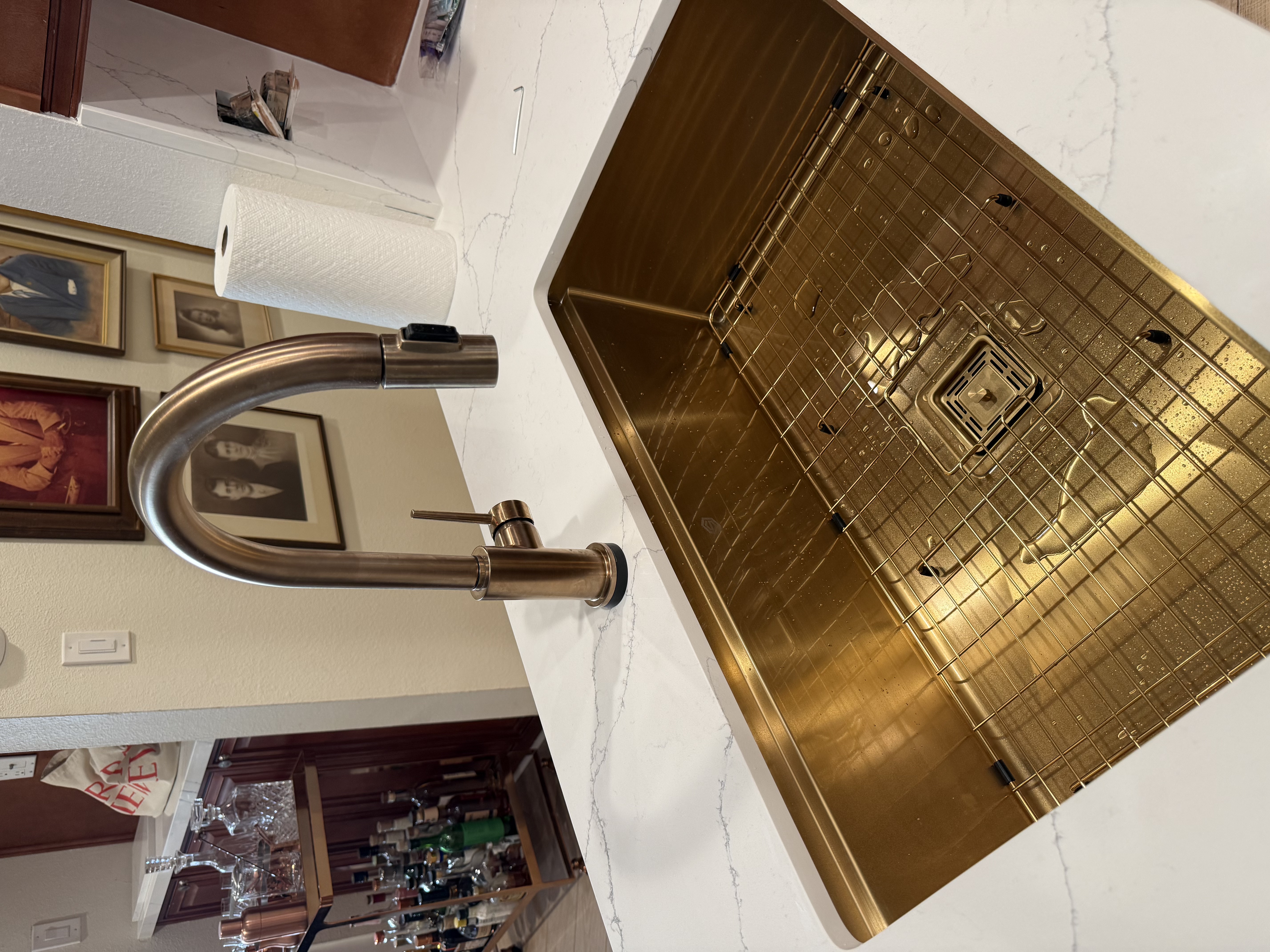 Close-up of gold kitchen sink and faucet installation
